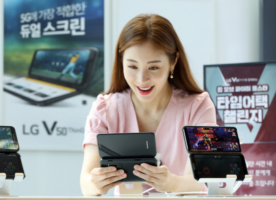 LG전자 모델이 LG V50 씽큐 와 LG 듀얼스크린으로 모바일 게임을 즐기고 있다. LG전자 제공